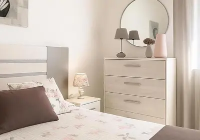 a bedroom with a bed with a dresser and a mirror at 