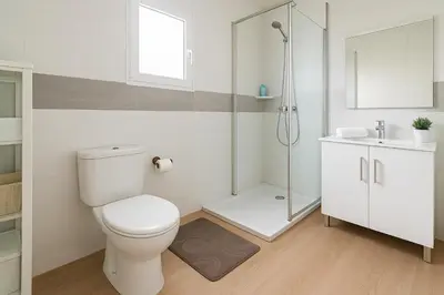 a white bathroom with a toilet and a shower at 