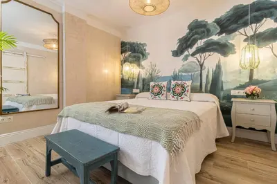 a bedroom with a bed with a large painting on the wall at Cathedral Keepers - Exclusive apartment in Jerez in Jerez de la Frontera