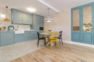 a kitchen with blue cabinets and a table and chairs at Cathedral Keepers - Exclusive apartment in Jerez in Jerez de la Frontera