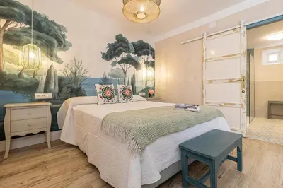 a bedroom with a bed and a painting on the wall at Cathedral Keepers - Exclusive apartment in Jerez in Jerez de la Frontera