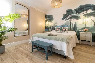 a bedroom with a bed and a painting on the wall at Cathedral Keepers - Exclusive apartment in Jerez in Jerez de la Frontera