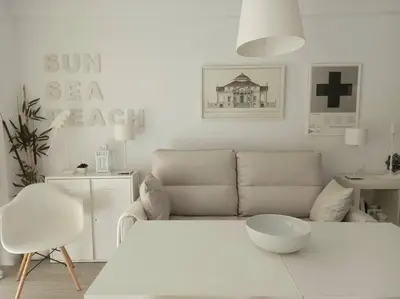 a white living room with a couch and a table at Alegrías de Cádiz by Gades Gestión in Cádiz