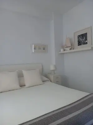 a bedroom with a white bed with two pillows at Alegrías de Cádiz by Gades Gestión in Cádiz