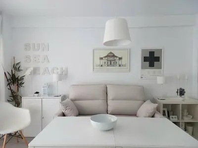 a white living room with a couch and a table at Alegrías de Cádiz by Gades Gestión in Cádiz