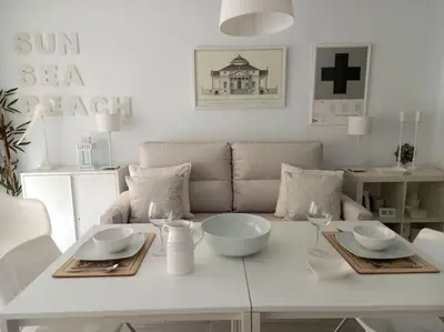 a white table with bowls and wine glasses on it at Alegrías de Cádiz by Gades Gestión in Cádiz