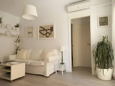 a living room with a white couch and a plant at Alegrías de Cádiz by Gades Gestión in Cádiz