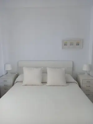 a bedroom with a white bed with two pillows at Alegrías de Cádiz by Gades Gestión in Cádiz