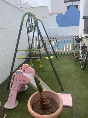 a small potted plant in a pot next to a playground at Apartamento in Sanlúcar de Barrameda