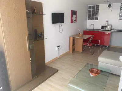 a small living room with a kitchen and a table at Apartamento in Sanlúcar de Barrameda