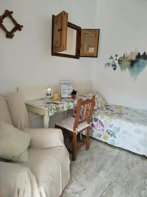 a living room with a chair and a desk at Apartamentos La Campana 5 in Jerez de la Frontera