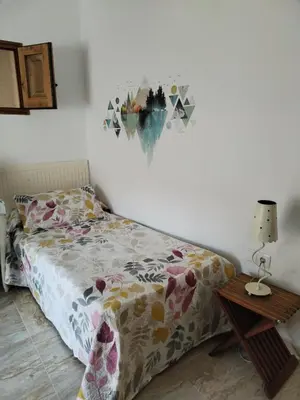 a bedroom with a bed and a table with a lamp at Apartamentos La Campana 5 in Jerez de la Frontera