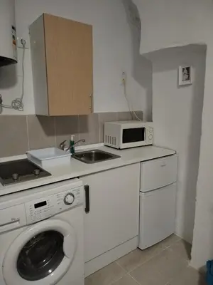 a kitchen with a washing machine and a microwave at Apartamentos La Campana 5 in Jerez de la Frontera