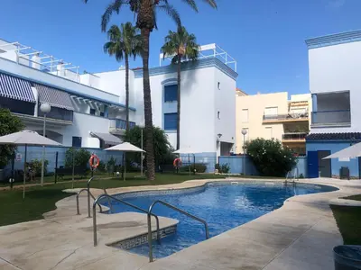 a swimming pool in front of a building with palm trees at AMPLIO PISO EN COSTA BALLENA A 100 M DE LA PLAYA in Costa Ballena