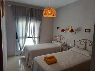 a bedroom with two beds and a window at AMPLIO PISO EN COSTA BALLENA A 100 M DE LA PLAYA in Costa Ballena