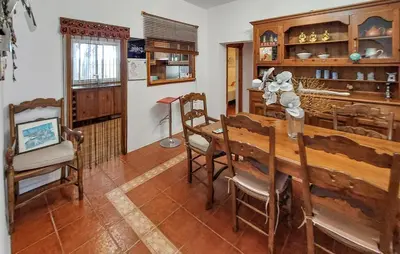 a dining room with a wooden table and chairs at La Marciana - piscina pista tenis futbol y baloncesto privado - Bungalow externo independiente in Chiclana de la Frontera