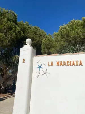 a white wall with a sign that reads la mariana at La Marciana - piscina pista tenis futbol y baloncesto privado - Bungalow externo independiente in Chiclana de la Frontera