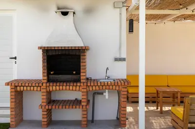 an outdoor brick oven in a patio with a bench at Complejoschiclana in Chiclana de la Frontera