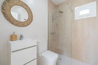a bathroom with a shower and a toilet and a mirror at Complejoschiclana in Chiclana de la Frontera
