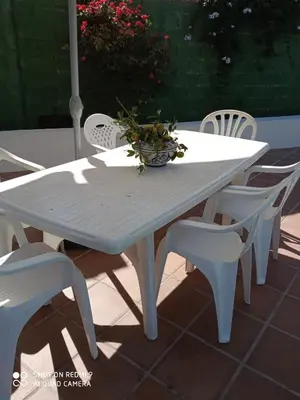 a white table and chairs with a bowl of flowers on it at Casa Mirador del Lago in Arcos de la Frontera
