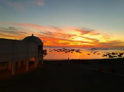a sunset on the beach with boats in the water at Apartamento en el centro a 200 m de la playa in Cádiz