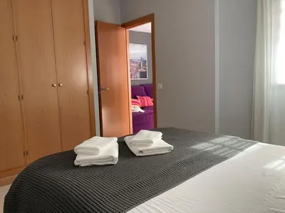 two towels sitting on a bed in a bedroom at Apartamento en el centro a 200 m de la playa in Cádiz
