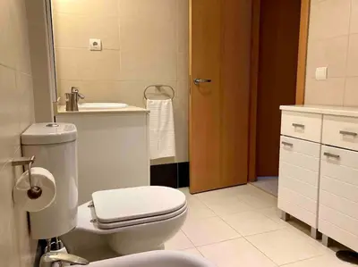 a bathroom with a white toilet and a sink at Apartamento en el centro a 200 m de la playa in Cádiz