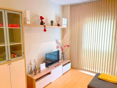 a living room with a television on a white shelf at Apartamento Puerta del Mar in Cádiz