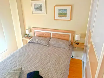 a bed in a bedroom with two lamps and two tables at Apartamento Puerta del Mar in Cádiz