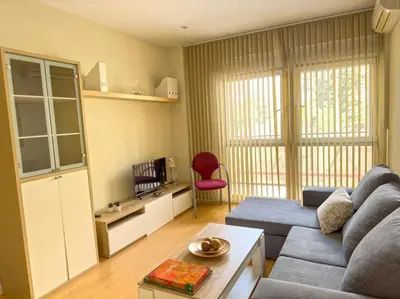 a living room with a blue couch and a red chair at Apartamento Puerta del Mar in Cádiz