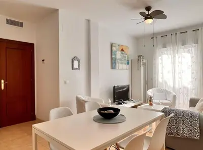 a living room with a white table and chairs at SibsSanlucar Carril SanDiego Centro Familias Garaje in Sanlúcar de Barrameda
