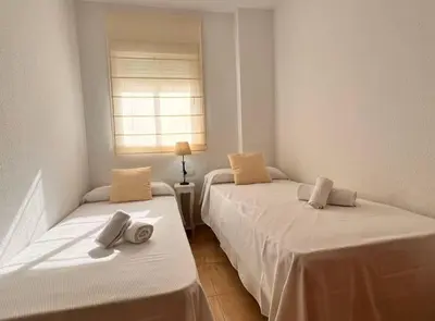 two twin beds in a room with a window at SibsSanlucar Carril SanDiego Centro Familias Garaje in Sanlúcar de Barrameda