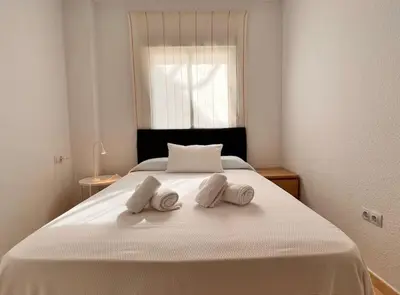 a white bed with two pillows on top of it at SibsSanlucar Carril SanDiego Centro Familias Garaje in Sanlúcar de Barrameda