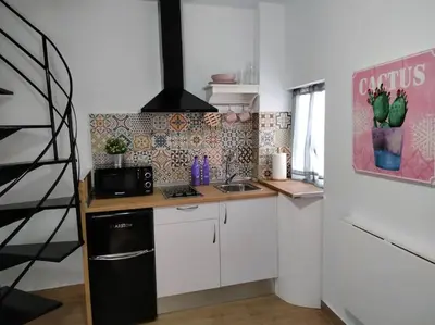 a kitchen with white cabinets and a black refrigerator at CASITA PINYPON in Jerez de la Frontera