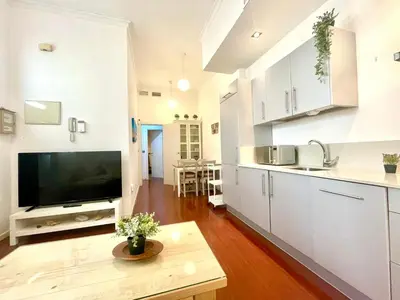 a kitchen with white cabinets and a flat screen tv at GATU PREMIUM La Brisa 