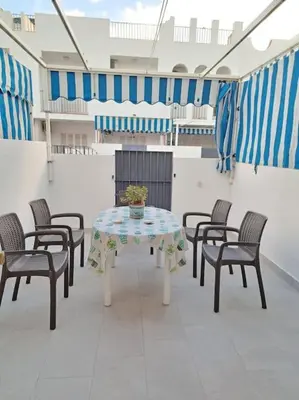 a table and chairs on a rooftop patio at Dúplex en primera línea de playa 15 in Sanlúcar de Barrameda