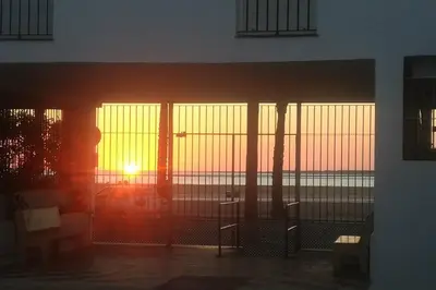 a sunset seen through the windows of a building at Dúplex en primera línea de playa 15 in Sanlúcar de Barrameda