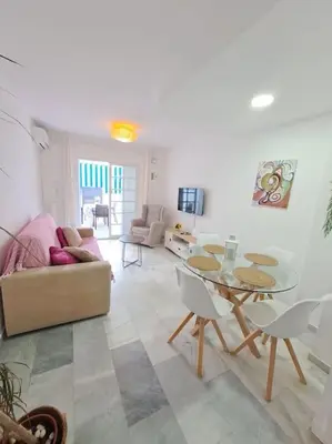 a living room with a table and a couch at Dúplex en primera línea de playa 15 in Sanlúcar de Barrameda