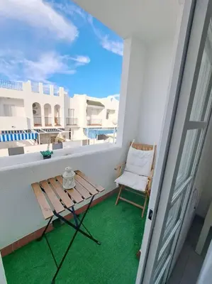 a porch with a bench and a chair on a balcony at Dúplex en primera línea de playa 15 in Sanlúcar de Barrameda