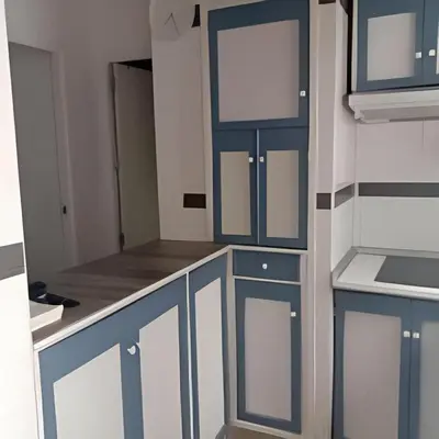a kitchen with blue and white cabinets in a room at Castelar in Rota