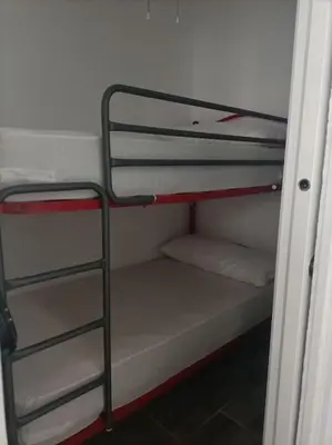 a bunk bed room with two bunk beds and a ladder at Castelar in Rota