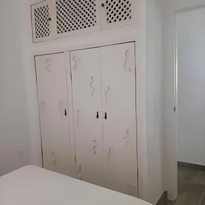 a white cabinet with stenciled doors in a room at Castelar in Rota