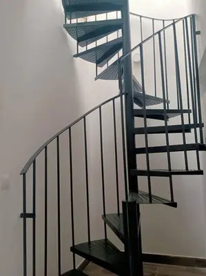 a spiral staircase in a white wall with a stair case at Castelar in Rota