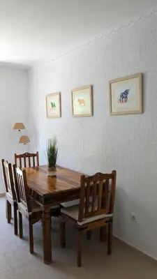a dining room table with chairs and a wooden table at Viva Piso Jerez in Jerez de la Frontera