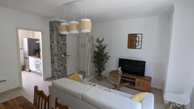 a living room with a white couch and a television at Viva Piso Jerez in Jerez de la Frontera