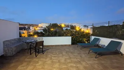a rooftop patio with chairs and a table at night at Viva Piso Jerez in Jerez de la Frontera