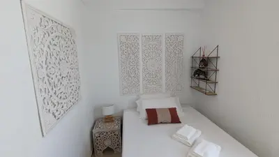 a small bedroom with a bed and white walls at Viva Piso Jerez in Jerez de la Frontera
