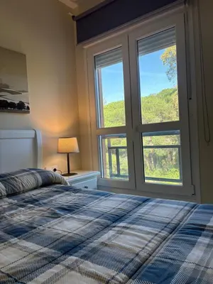 a bedroom with a bed and a large window at Áncora apartamento in El Puerto de Santa María