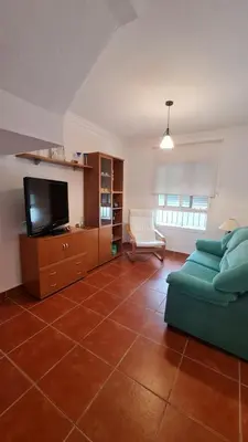 a living room with a couch and a tv at Vaca House in El Puerto de Santa María