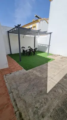a patio with two picnic tables on the grass at Vaca House in El Puerto de Santa María